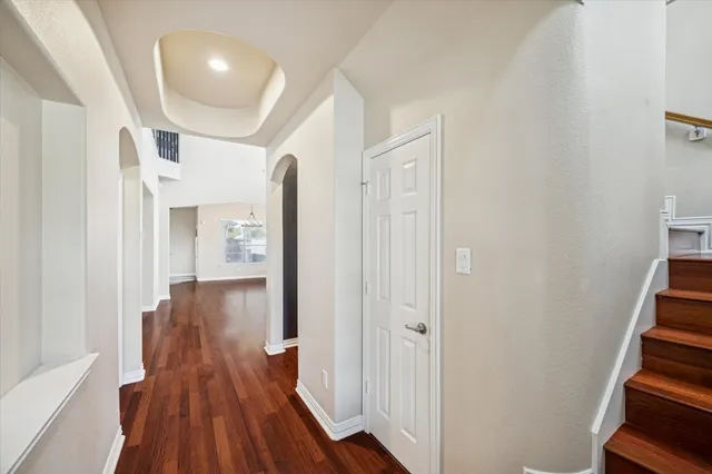 a view of a hallway with wooden floor and staircase