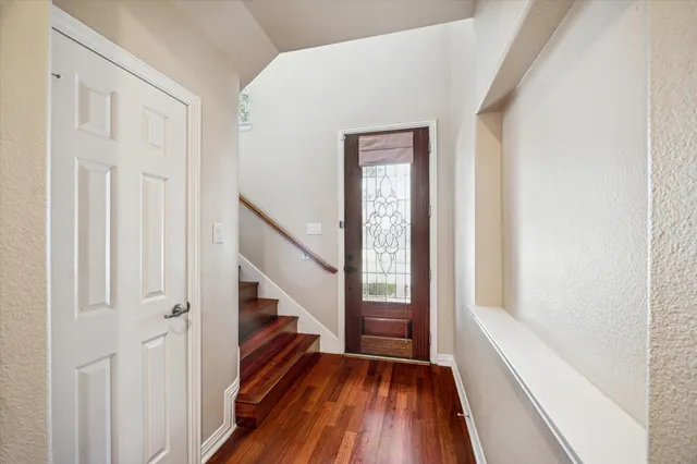 a view of a hallway with wooden floor and staircase