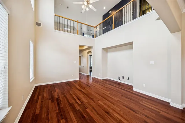a view of a big room with wooden floor and staircase