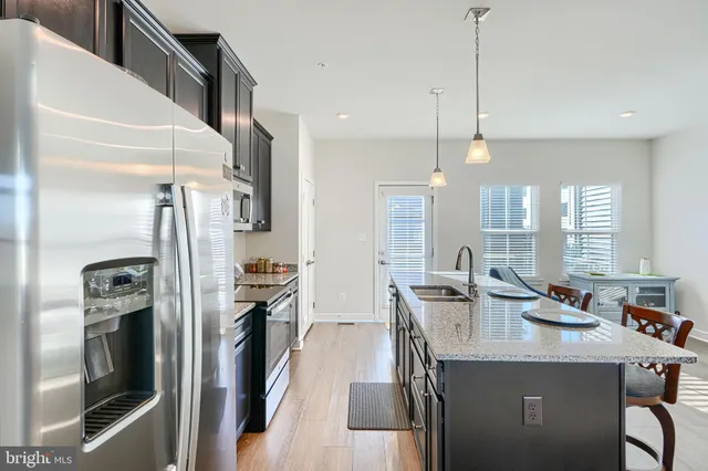 a kitchen with stainless steel appliances granite countertop a sink a stove and a refrigerator