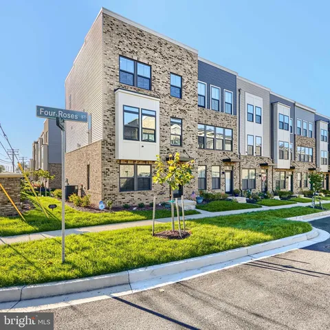 a front view of a building with garden and trees
