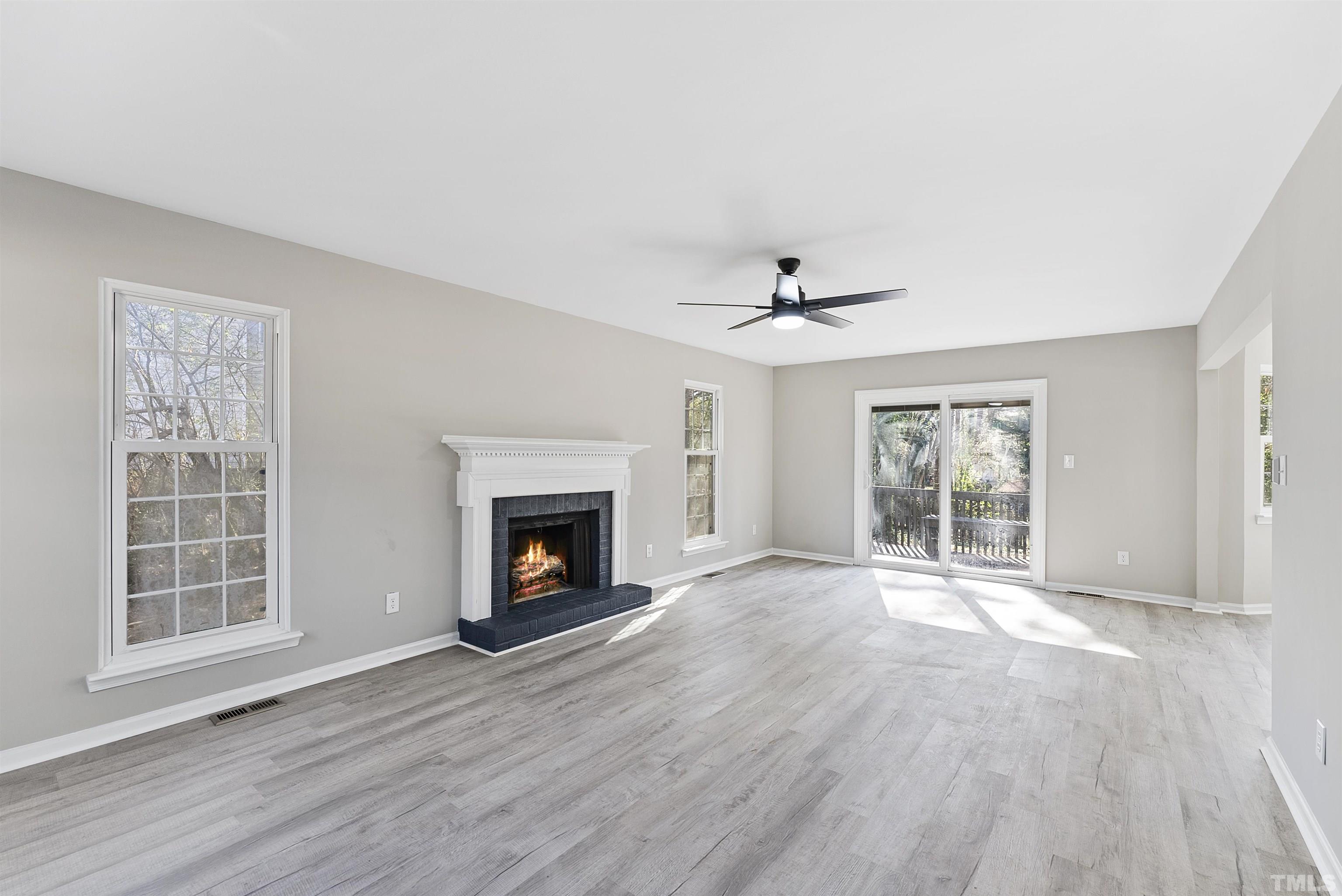 5500 Old Towne Road Raleigh, NC 27612 - Photo 4 of 21 a view of an empty room with wooden floor fireplace and a window