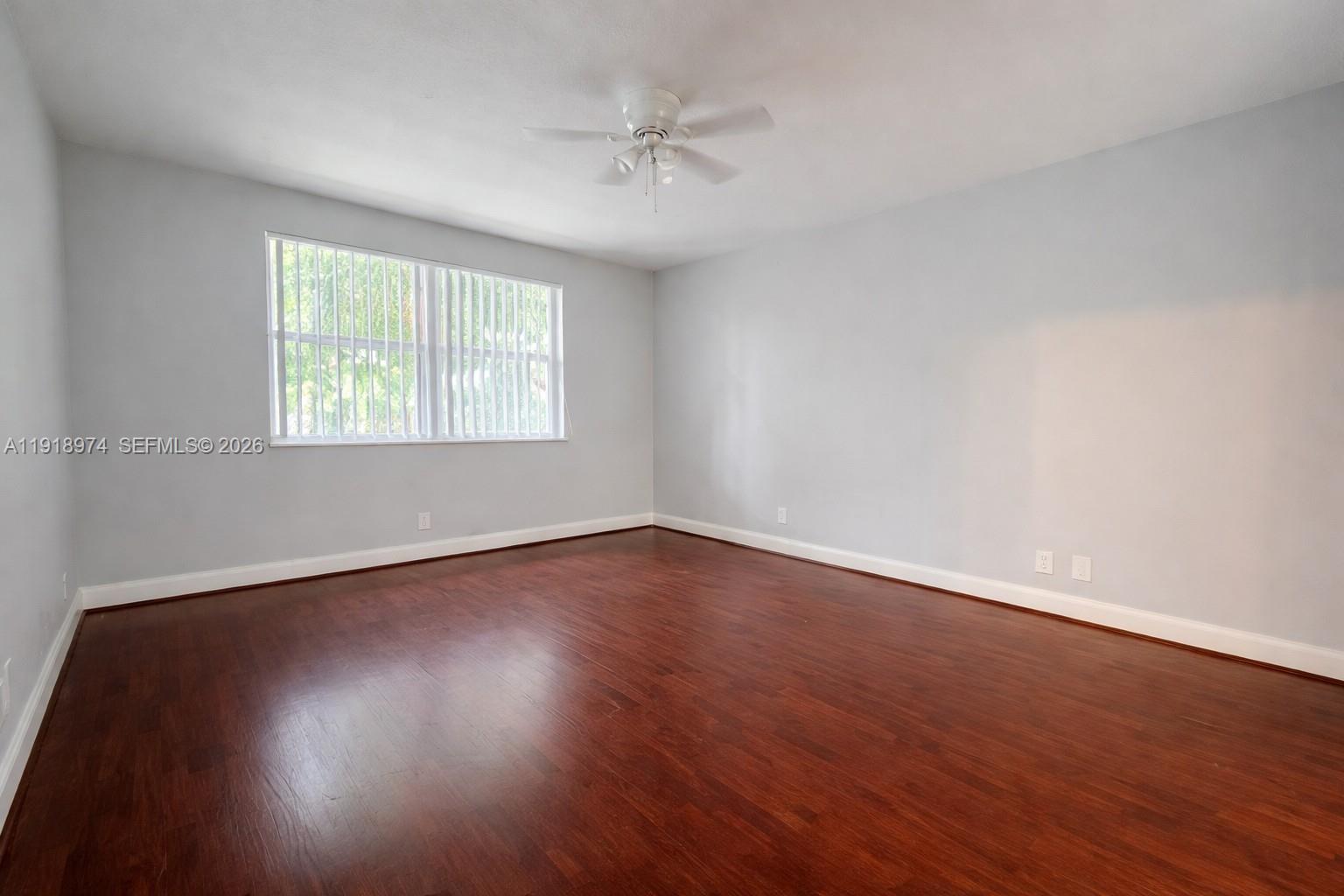 8801 Wiles Road, Unit 307 Coral Springs, FL 33067 - Photo 8 of 18 an empty room with wooden floor and windows