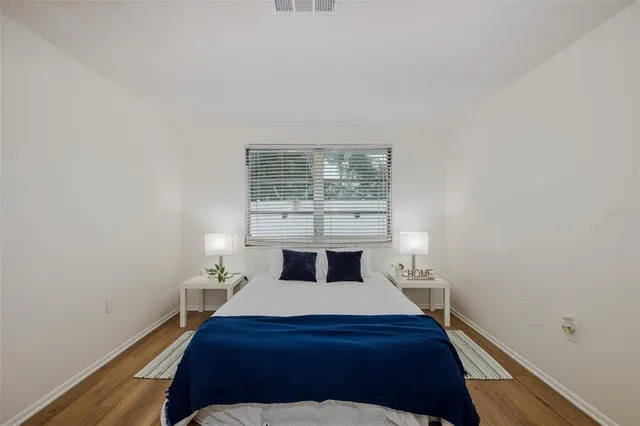 a bedroom with a bed and wooden floor