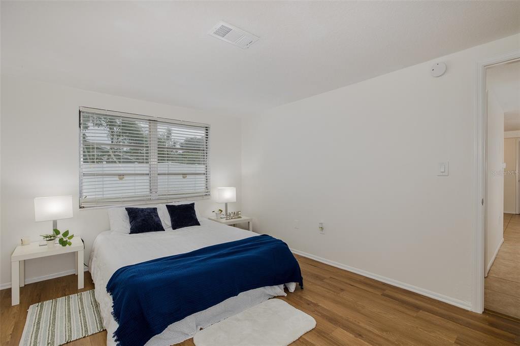 7437 Daggett Terrace New Port Richey, FL 34655 - Photo 20 of 38 a bedroom with a bed and wooden floor