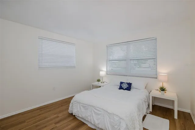 a bathroom with a granite countertop sink a toilet a mirror a vanity and shower