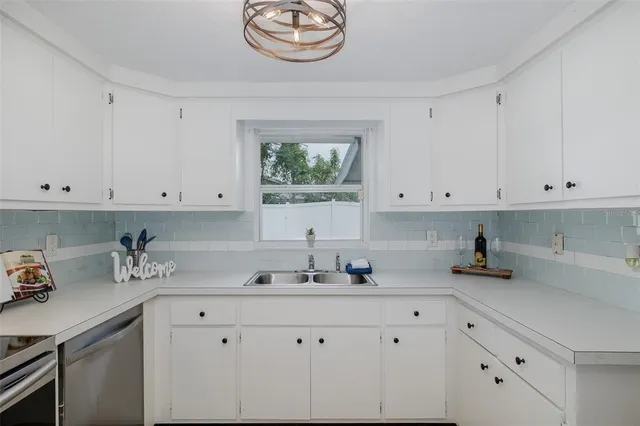 a kitchen with white cabinets and a sink