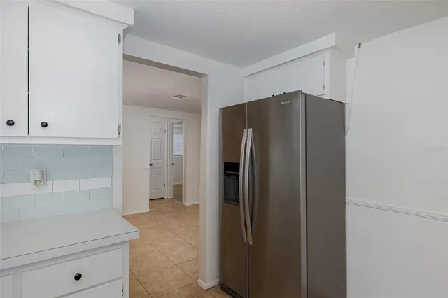 a kitchen with a refrigerator and cabinets