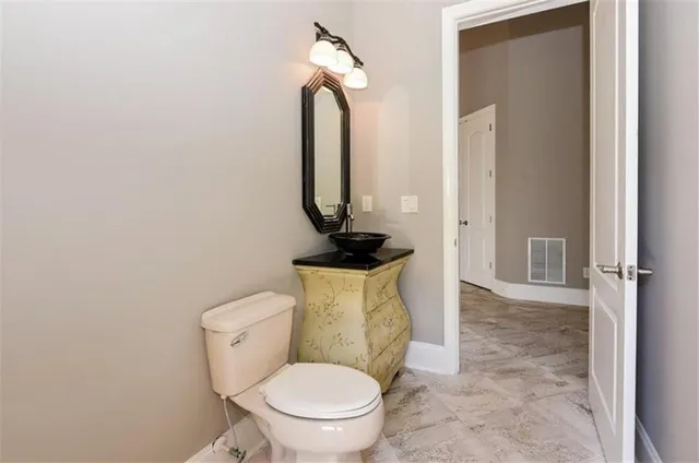 a bathroom with a toilet a sink and mirror