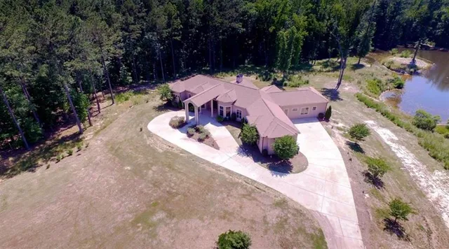 a view of a backyard with chairs and potted plants