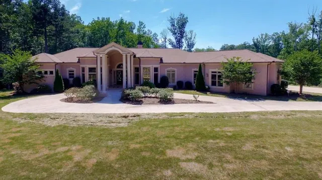 a view of a house with a yard and sitting area