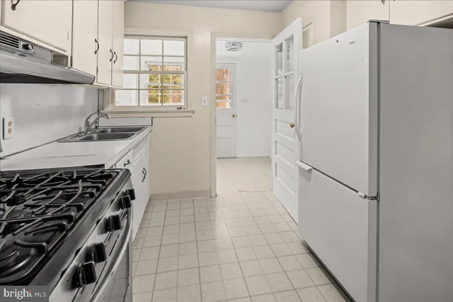 a kitchen with a stove a refrigerator and a sink