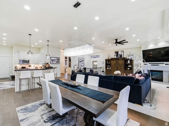 1154 Sunset Dunes Way Draper, UT 84020 - Photo 17 of 50 Dining space with light wood-type flooring, a glass covered fireplace, recessed lighting, and a ceiling fan