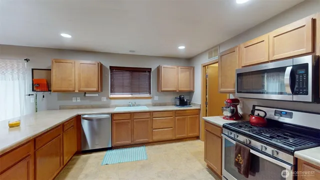 a kitchen with stainless steel appliances a sink stove and cabinets