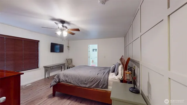 a bedroom with a bed ceiling fan and a window