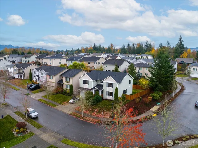 an aerial view of residential houses with outdoor space and lakeside