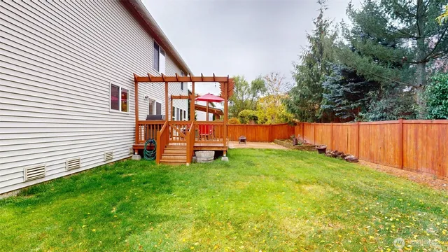 a view of a house with a big yard and large trees
