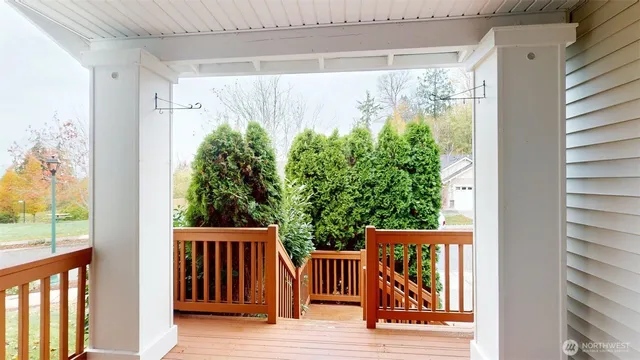 a view of a balcony with floor to ceiling windows and wooden fence