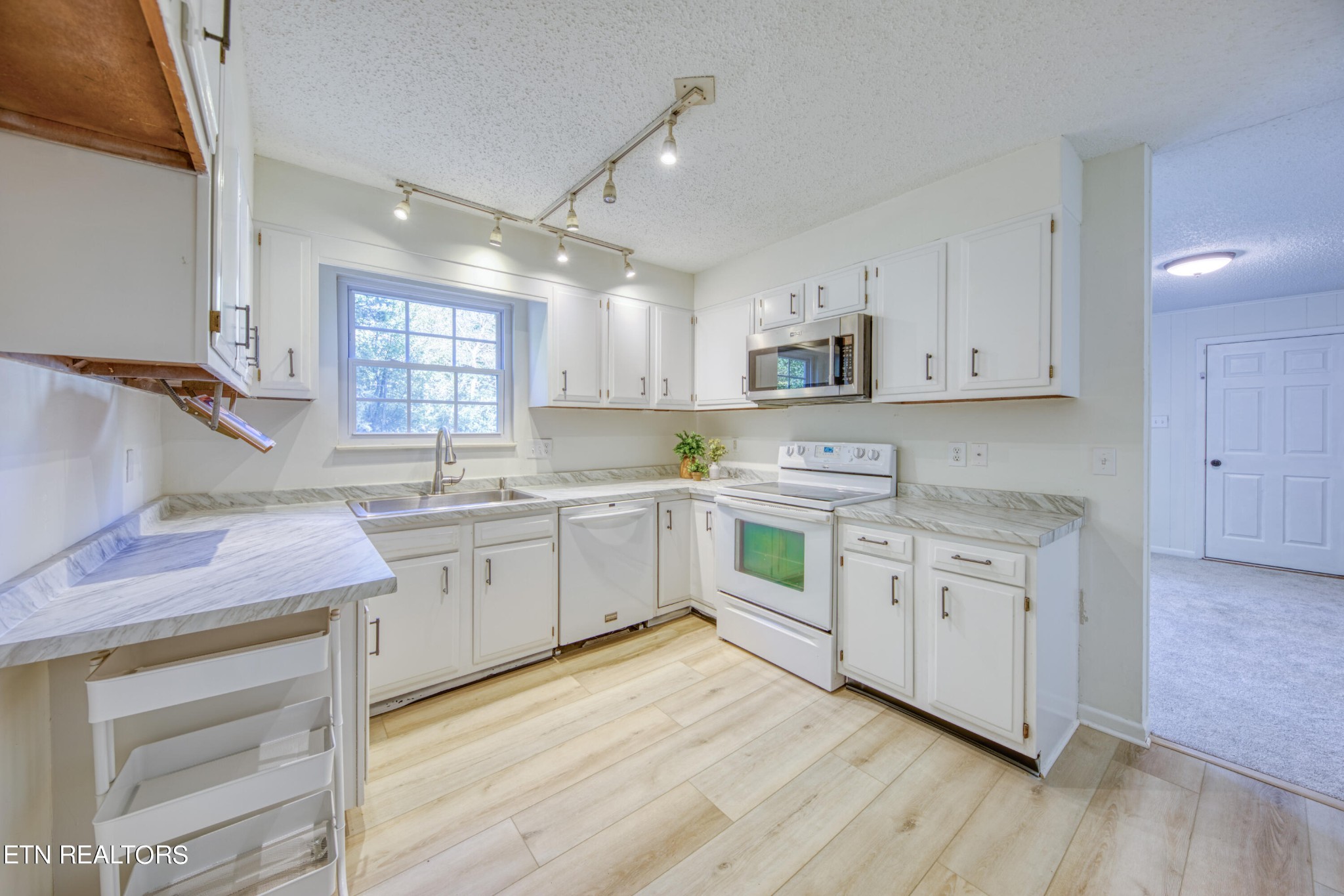 7329 Joyce Lane Powell, TN 37849 - Photo 4 of 28 a kitchen with granite countertop cabinets stainless steel appliances a sink and a window