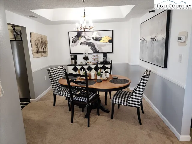 a view of a dining room with furniture a chandelier and wooden floor