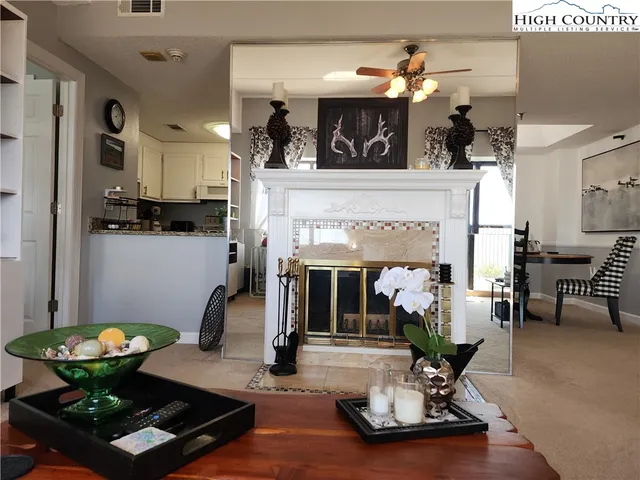 a living room with furniture fireplace and kitchen view