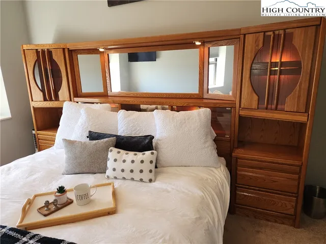 a bed room with a bed and a painting on the wall