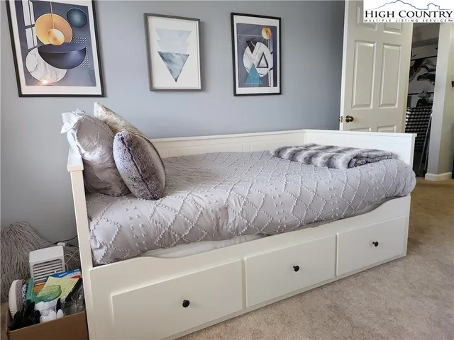 a bedroom with a bed and a painting on the wall