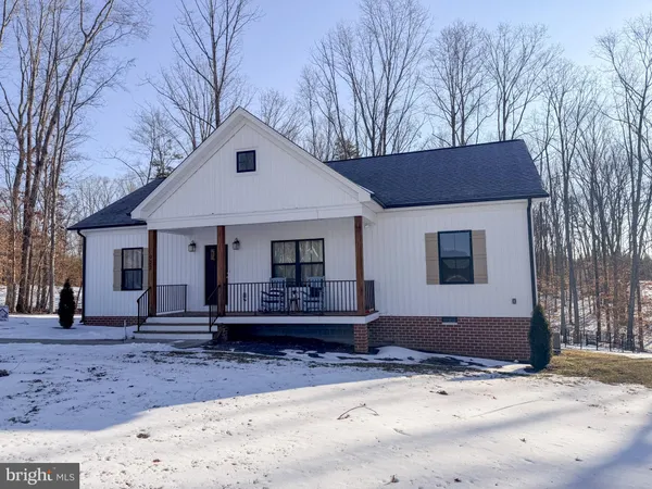 a front view of a house with a yard covered with snow in front of house