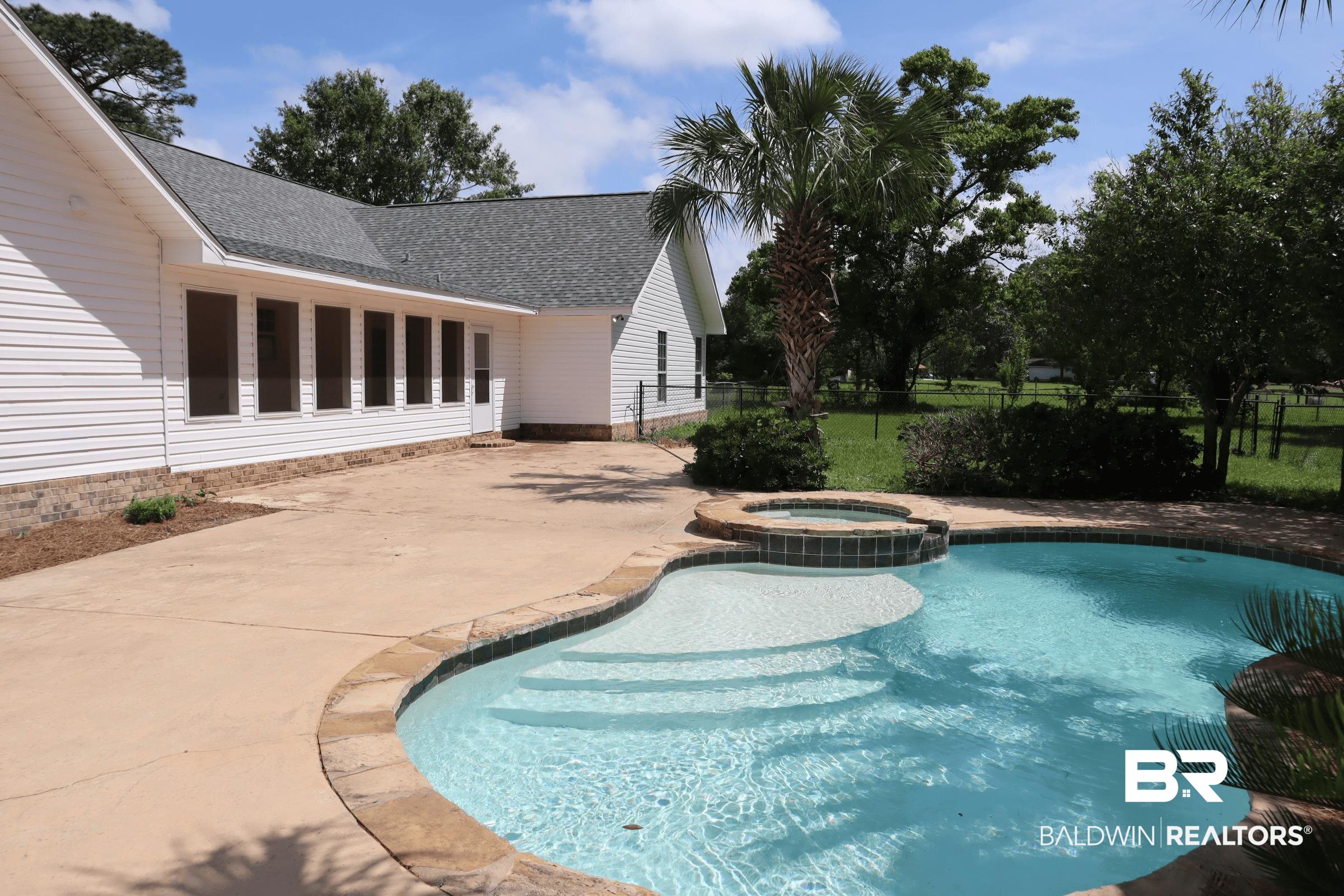 12150 Lee Bishop Road Irvington, AL 36544 - Photo 6 of 26 View of swimming pool featuring a pool with connected hot tub, fence, and a patio area