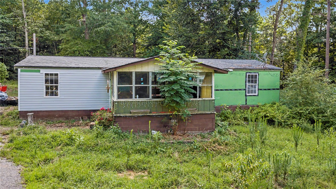 266 Ledford Farm Road Fair Play, SC 29643 - Photo 2 of 34 A charming fixer-upper set against a verdant wooded backdrop, offering privacy and potential.