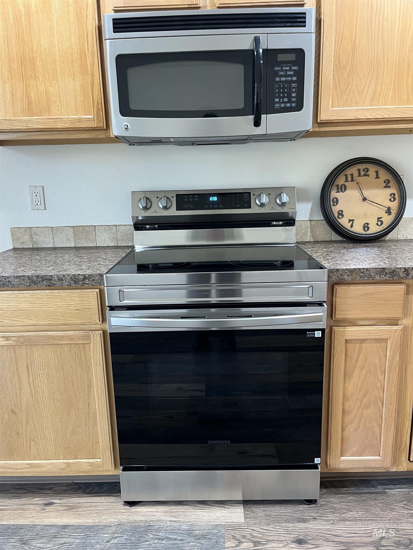 16535 Chino Avenue Caldwell, ID 83607 - Photo 11 of 26 Kitchen featuring appliances with stainless steel finishes, wood finished floors, and dark stone counters