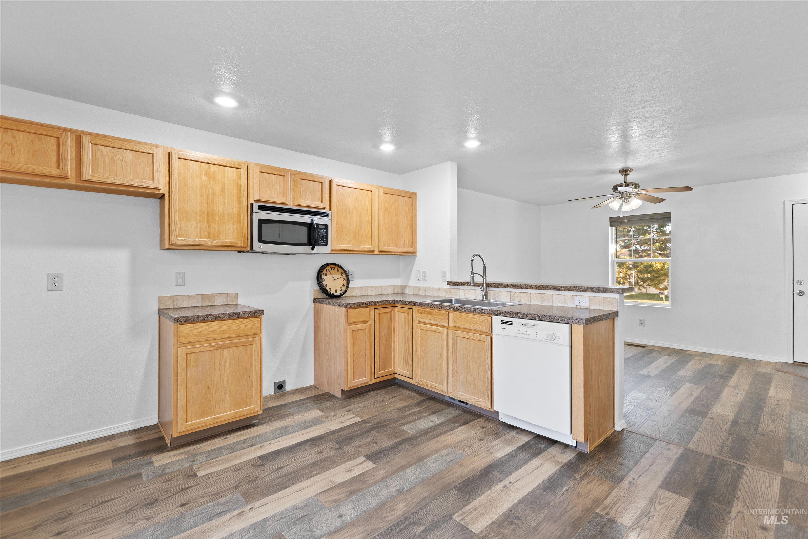 16535 Chino Avenue Caldwell, ID 83607 - Photo 12 of 26 Kitchen with recessed lighting, a peninsula, white dishwasher, dark countertops, and light brown cabinets