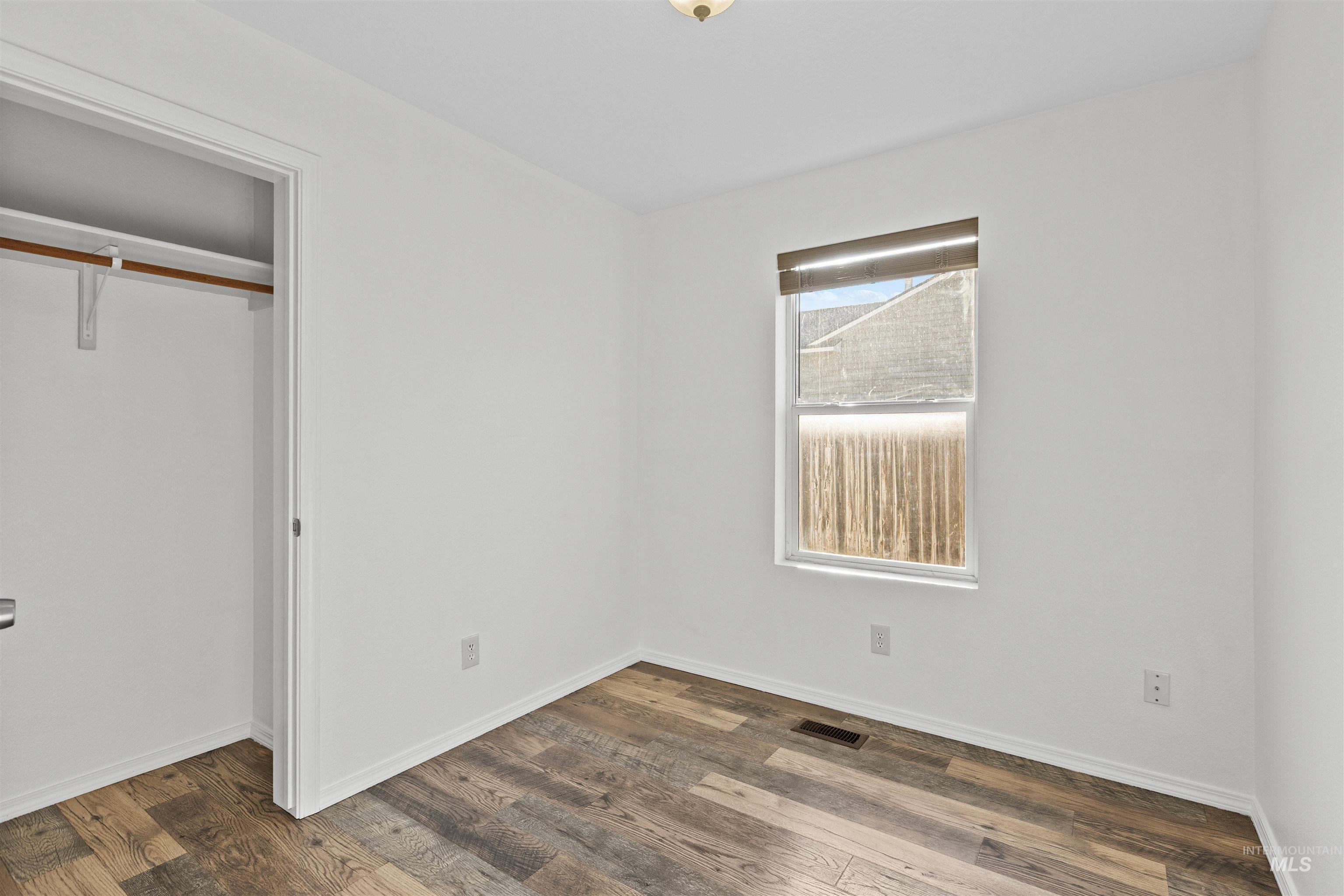 16535 Chino Avenue Caldwell, ID 83607 - Photo 18 of 26 Unfurnished bedroom featuring dark wood-style flooring and a closet
