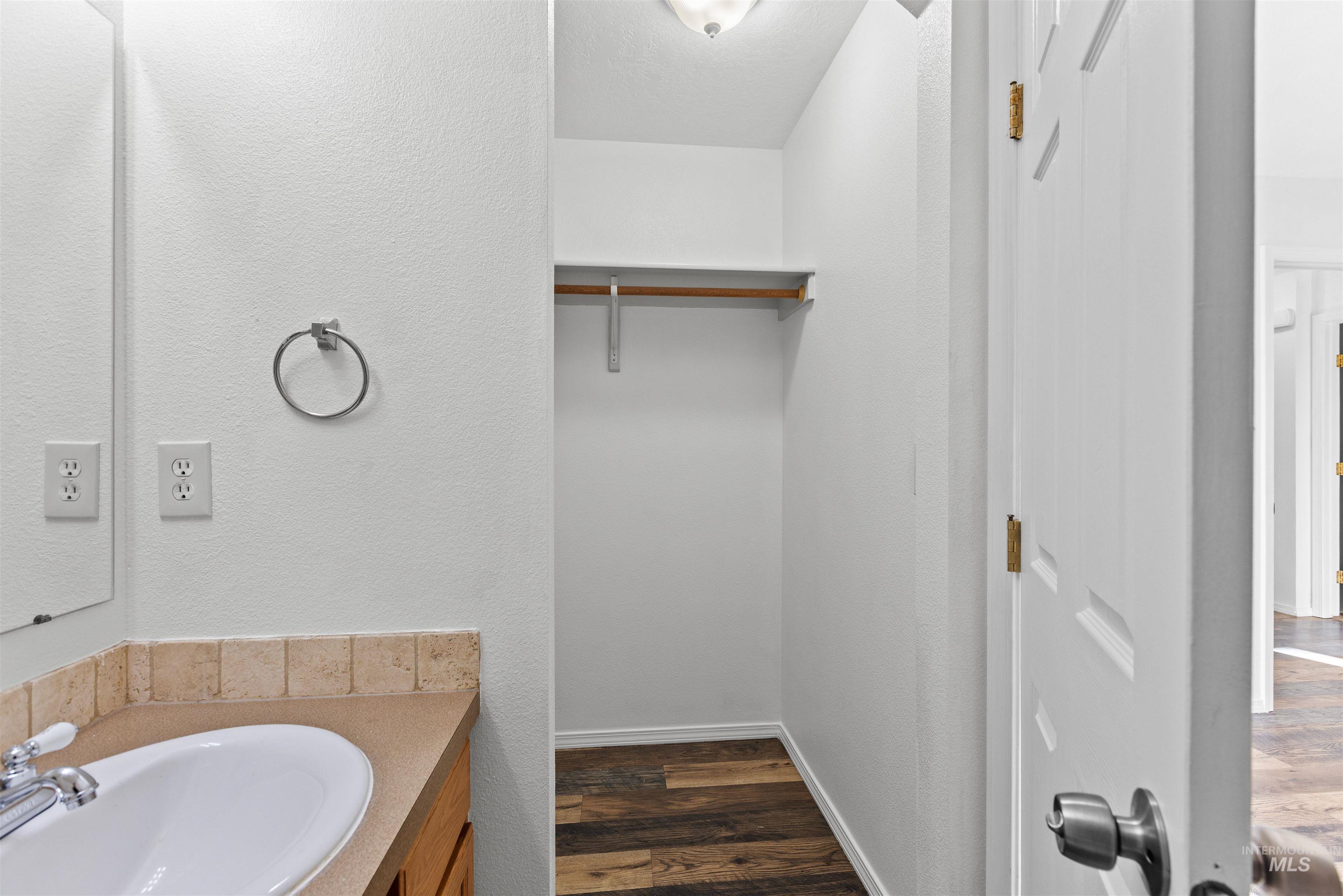 16535 Chino Avenue Caldwell, ID 83607 - Photo 22 of 26 Bathroom with vanity, dark wood-style floors, and a textured wall