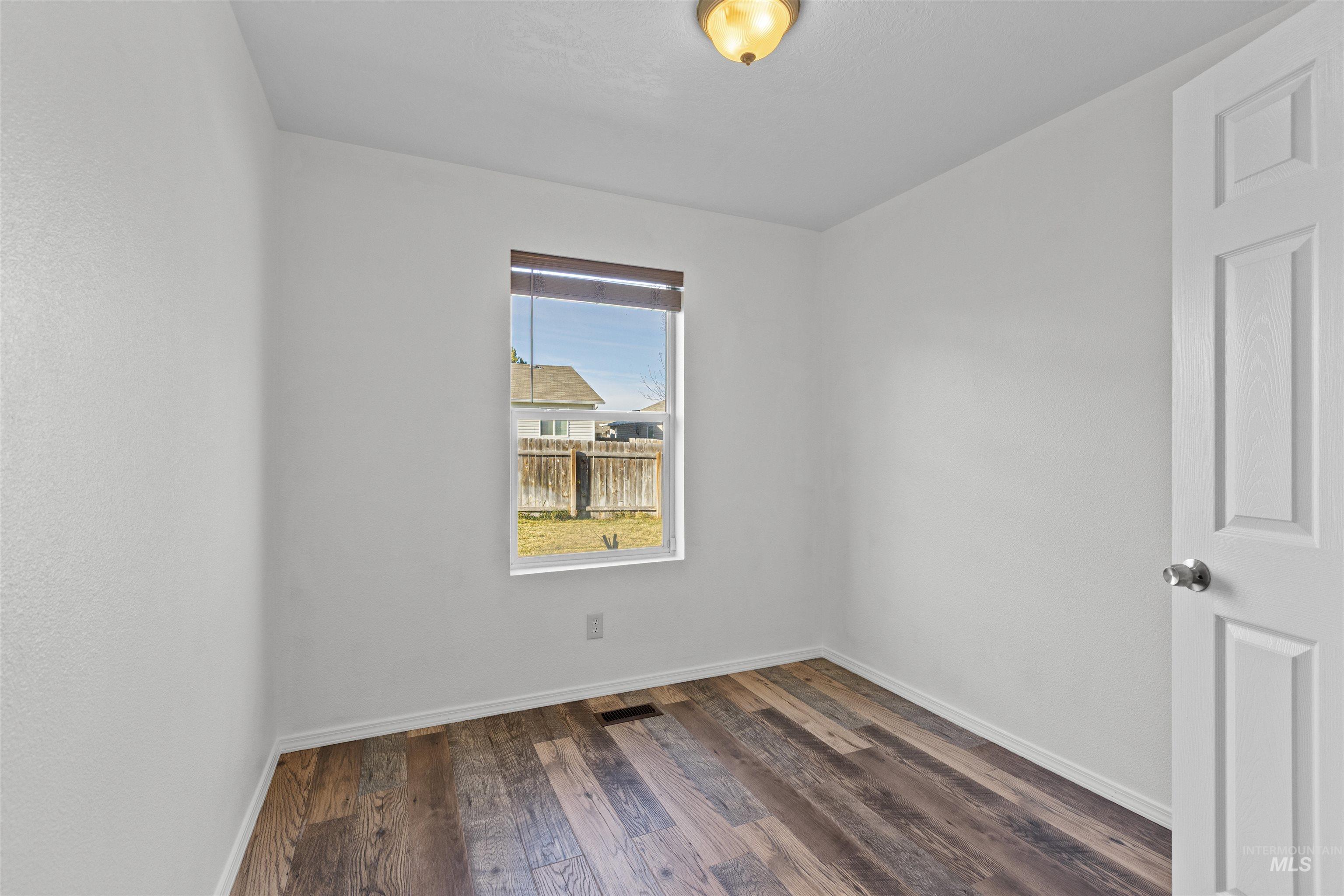 16535 Chino Avenue Caldwell, ID 83607 - Photo 23 of 26 Spare room with dark wood-style floors and baseboards