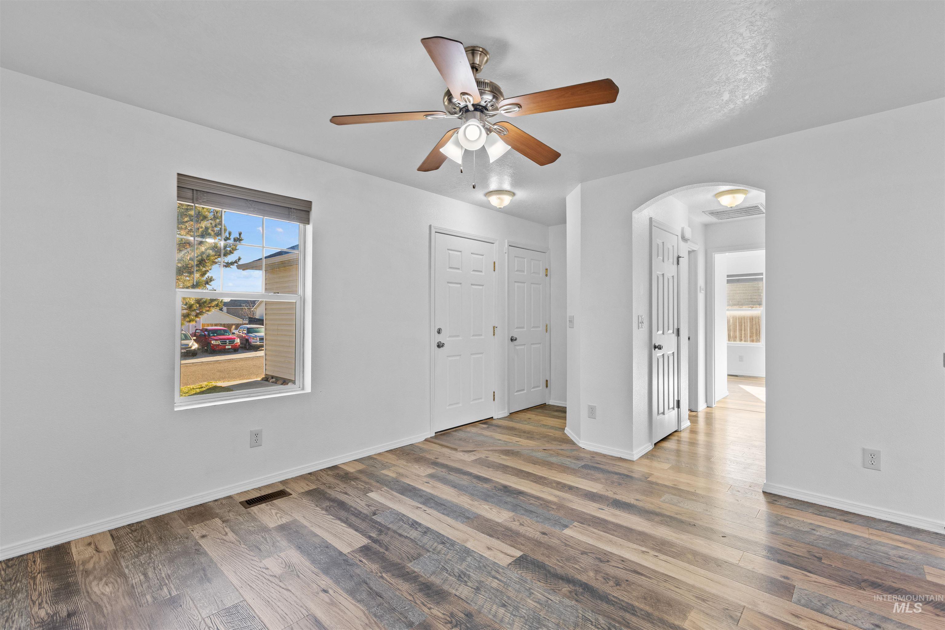 16535 Chino Avenue Caldwell, ID 83607 - Photo 4 of 26 Empty room featuring plenty of natural light, hardwood / wood-style flooring, and arched walkways