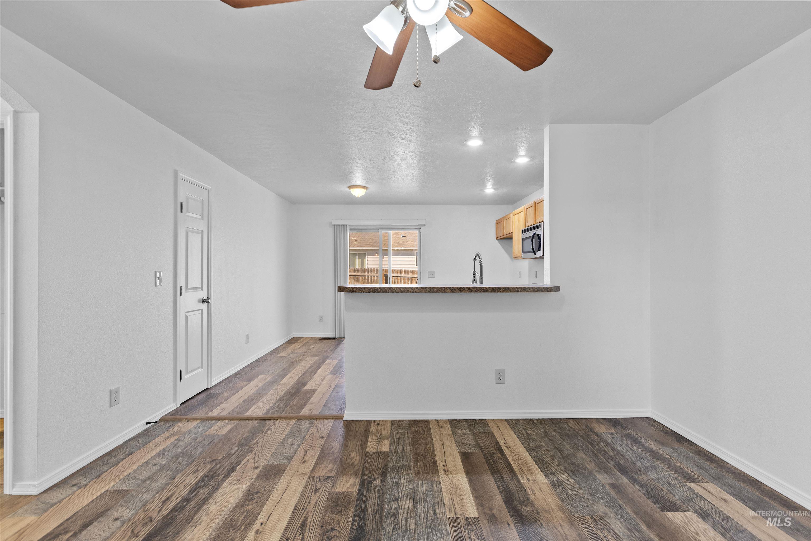 16535 Chino Avenue Caldwell, ID 83607 - Photo 8 of 26 Unfurnished living room featuring dark wood finished floors and ceiling fan