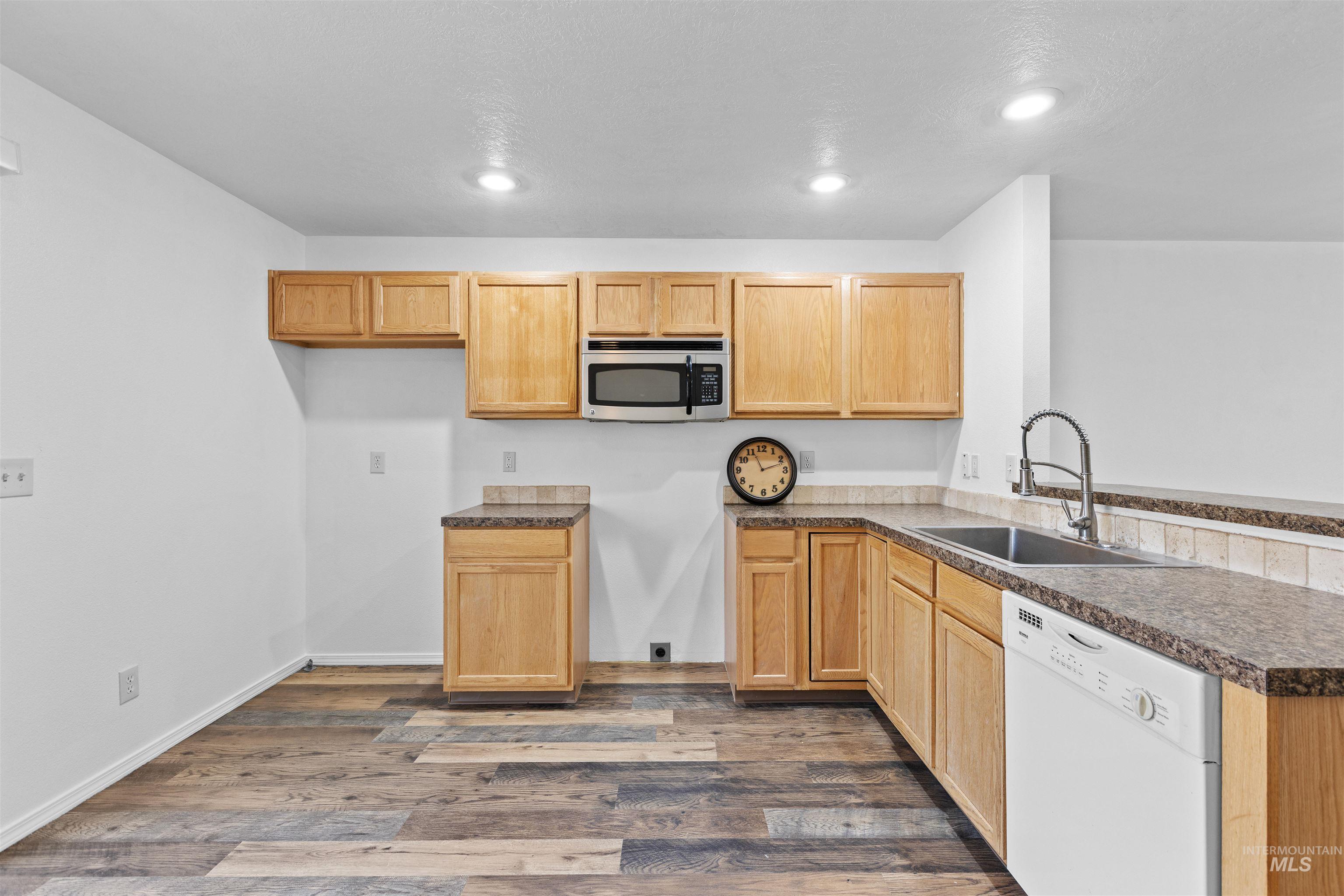 16535 Chino Avenue Caldwell, ID 83607 - Photo 10 of 26 Kitchen with dishwasher, dark countertops, dark wood-style floors, stainless steel microwave, and recessed lighting