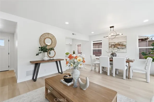 a dining room with wooden floor and chandelier