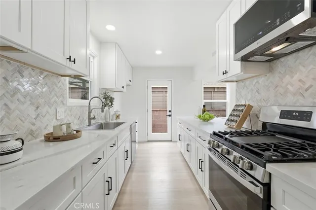 a large kitchen with stainless steel appliances granite countertop a lot of counter space and a sink