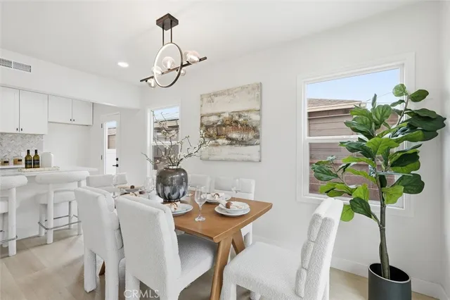 a dining room filled chandelier and wooden floor