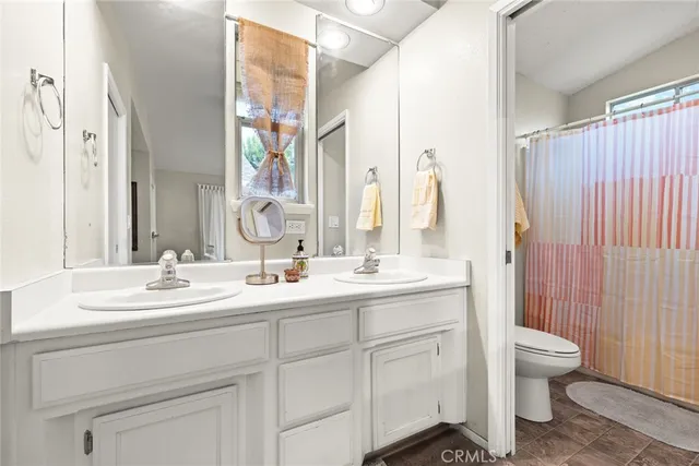 a bathroom with a double vanity sink toilet and shower