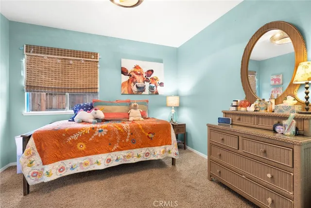 a bedroom with a bed and a mirror on dresser