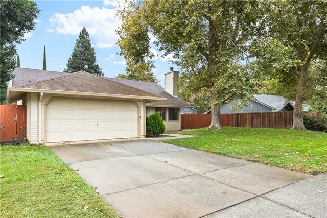 a view of a house with a yard and large tree
