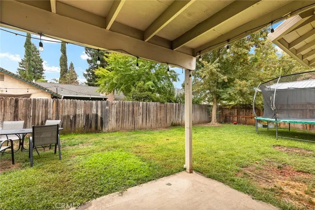 a backyard of a house with table and chairs