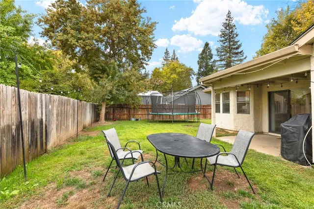 a view of a table and chairs in backyard of the house