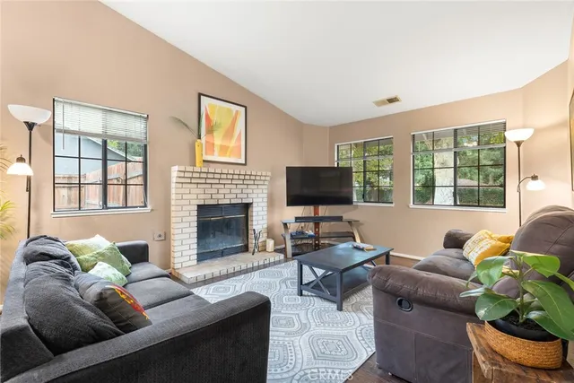 a living room with furniture a flat screen tv and a fireplace