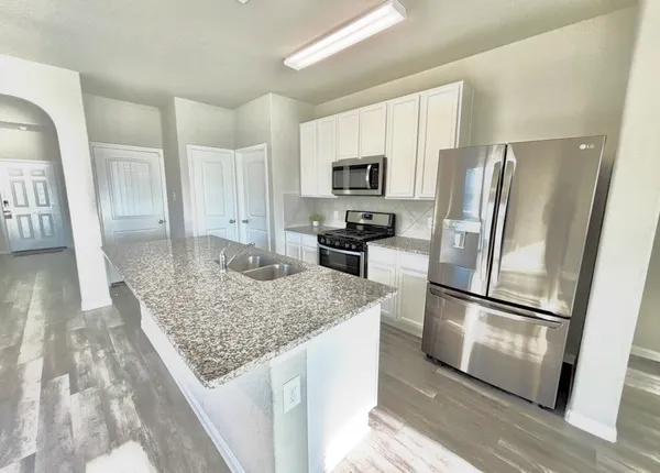 a kitchen with stainless steel appliances granite countertop a refrigerator and microwave