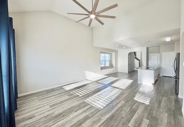 a view of a bedroom with wooden floor and a ceiling fan