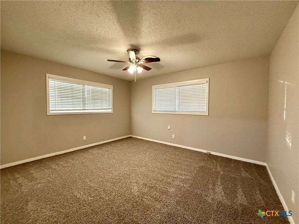 2407 East Airline Road Victoria, TX 77901 - Photo 20 of 38 an empty room with a window and a ceiling fan